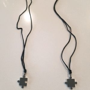 A pair of Chrome puzzle piece necklaces